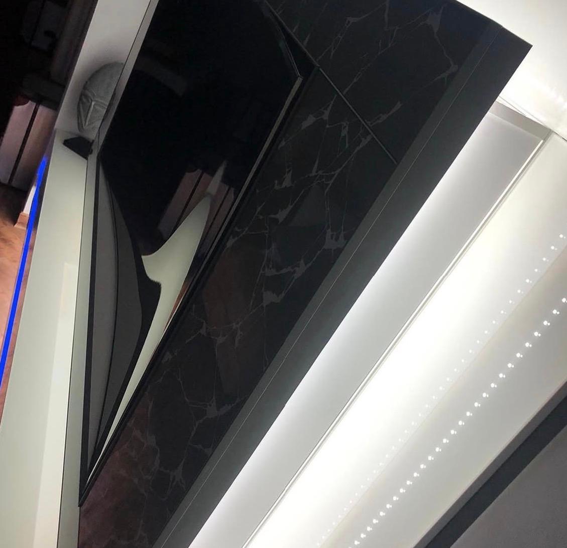 Close detail of the glass TV surround and illuminated wall panel.