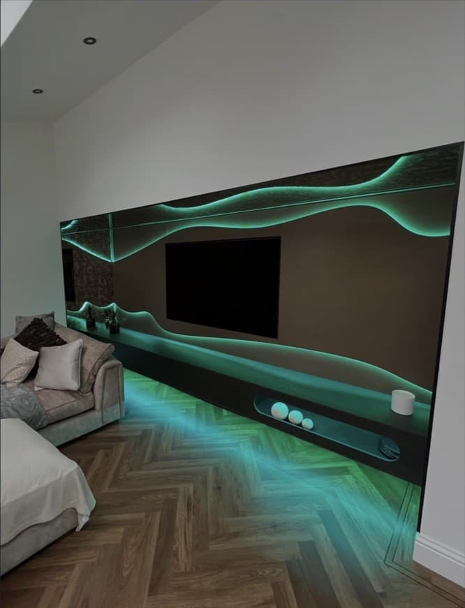 Bespoke media wall with illuminated wave detailing, floating cabinetry and green colour-changing LED lighting.