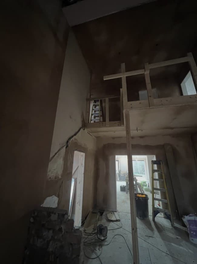 Double-height entrance space during construction before the staircase, glass balustrades and final finishes were installed.