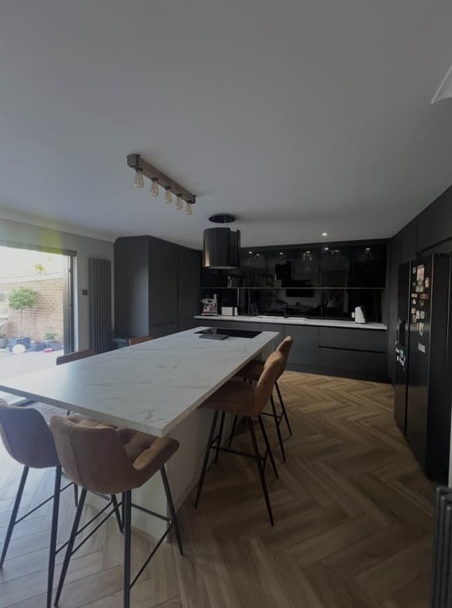 Bespoke matt anthracite kitchen with a large Calacatta marble island and dark fitted cabinetry.
