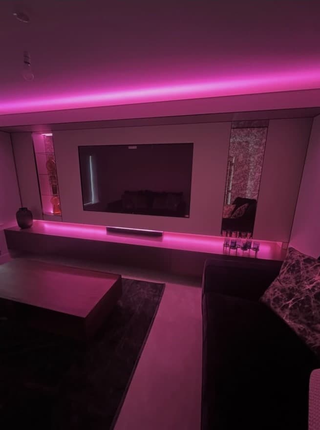 Bespoke media wall shown with vivid magenta colour-changing integrated lighting.