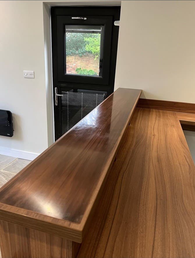 Close detail of the polished timber bar top and fitted bar cabinetry.