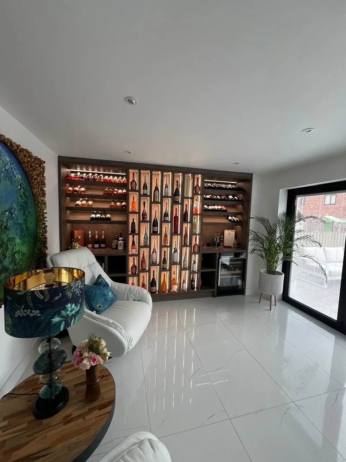 View across the seating area towards the illuminated wine display and glazed doors.