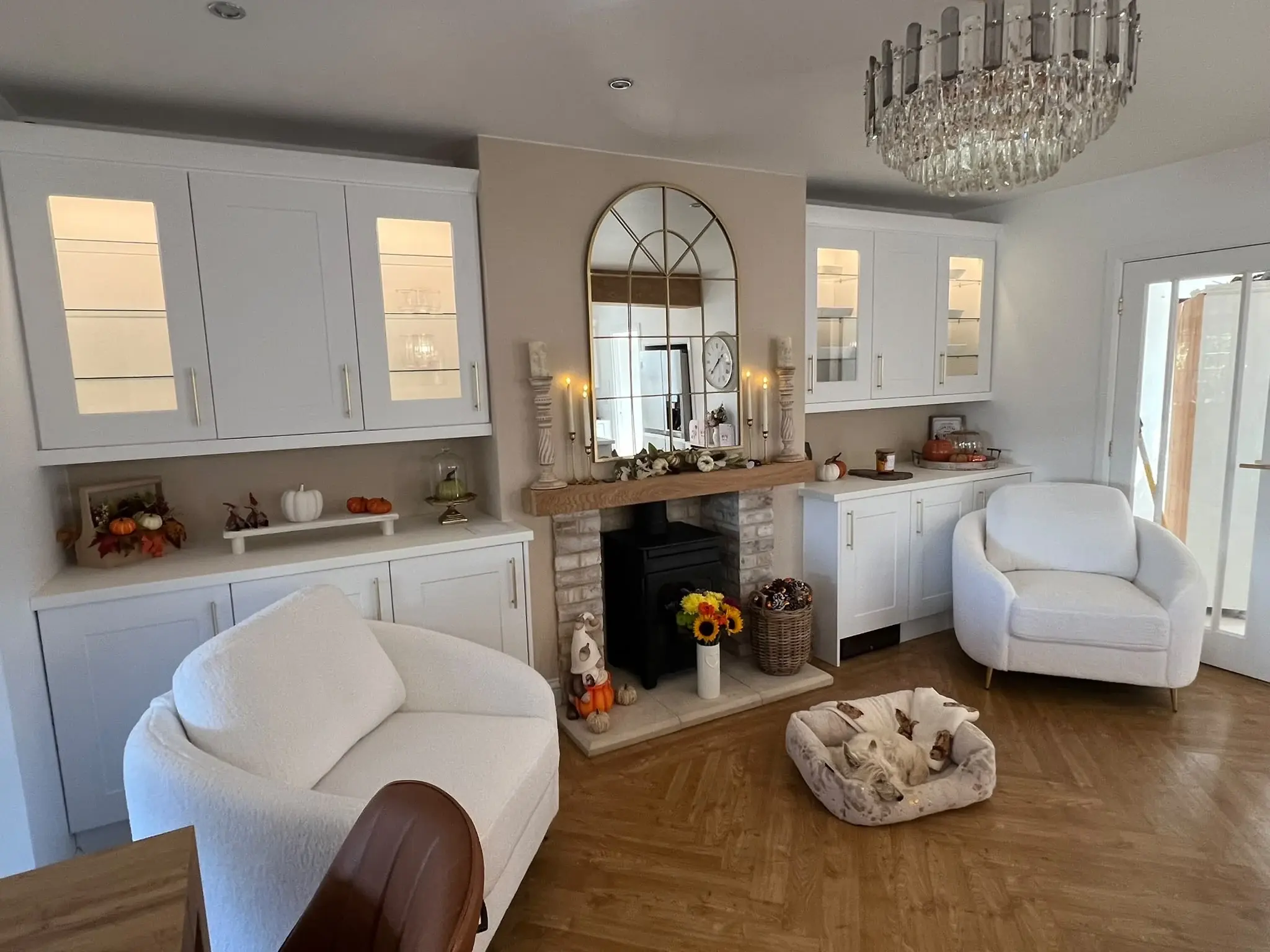 White glazed display cabinets and lower cupboards beside the separate fireplace.