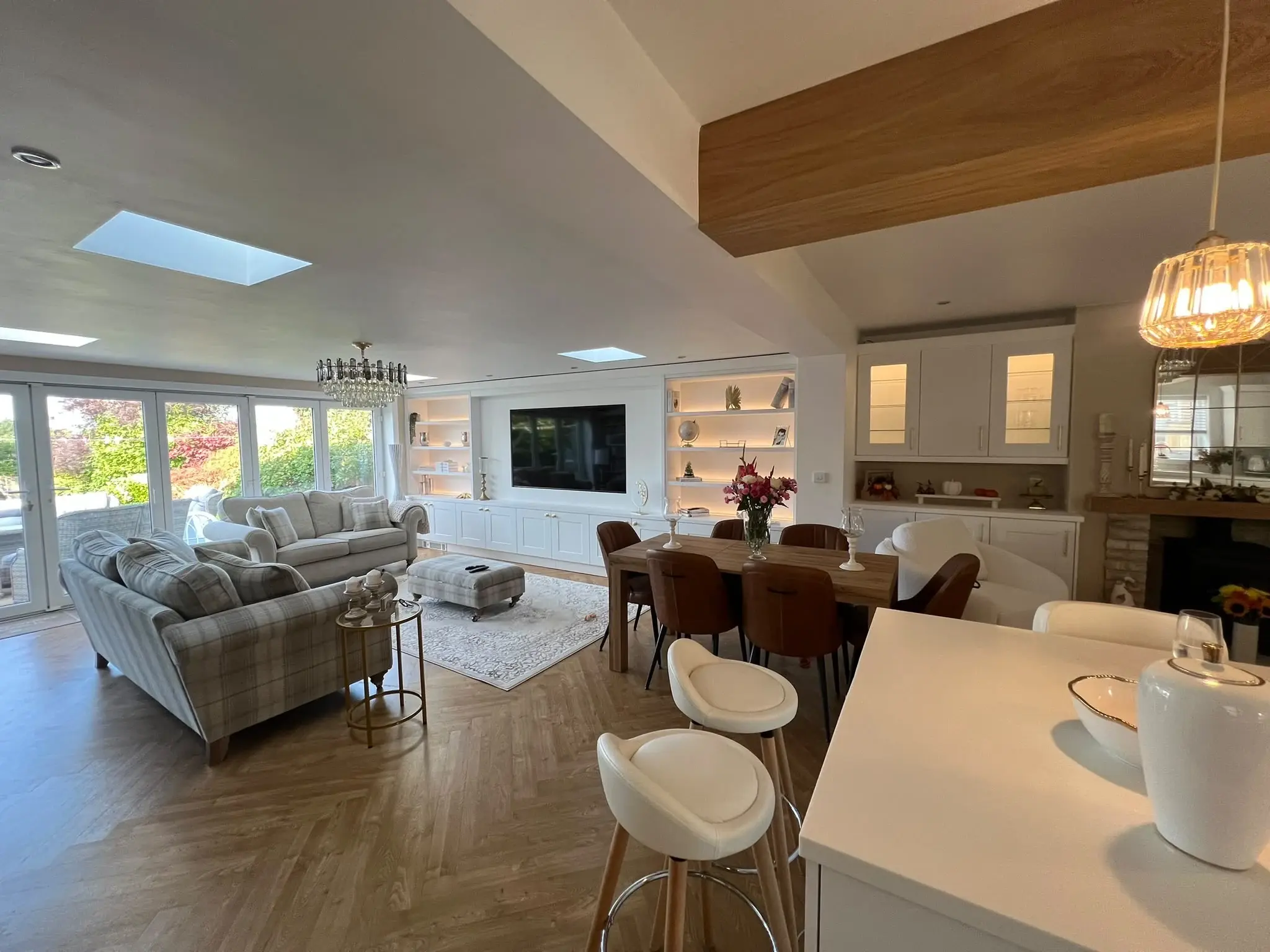 Alternative wide view from the white kitchen island towards the dining and living areas.