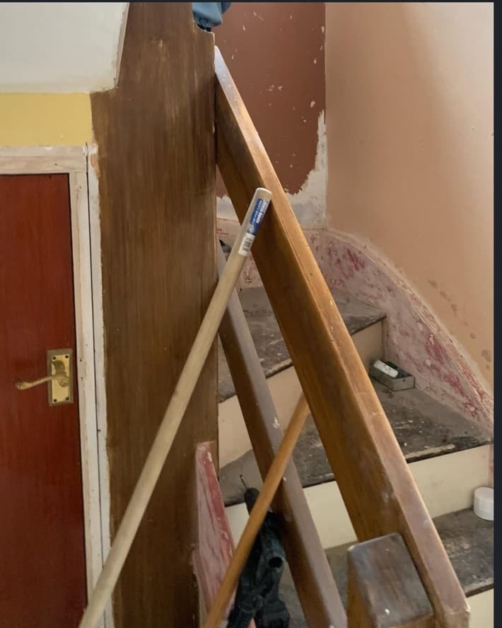 Original staircase before renovation with dark timber rails and unfinished stair surfaces.