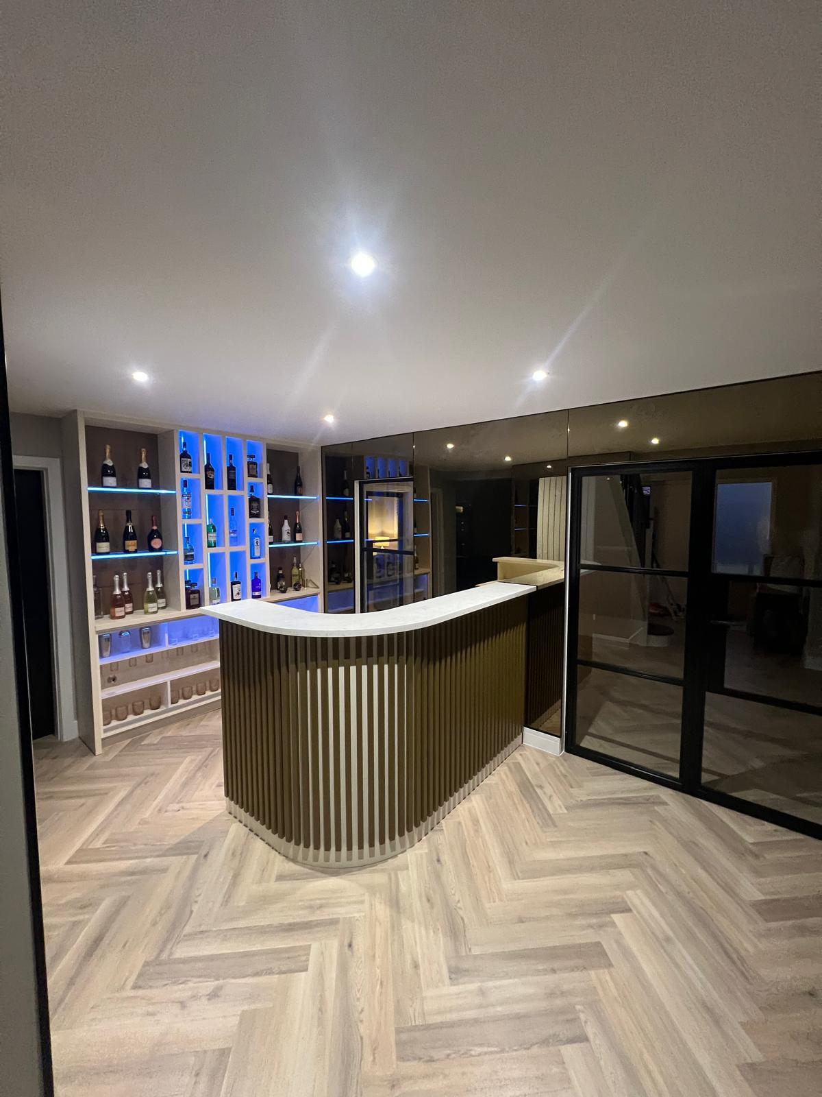 Curved joinery and integrated storage in the bespoke home bar.