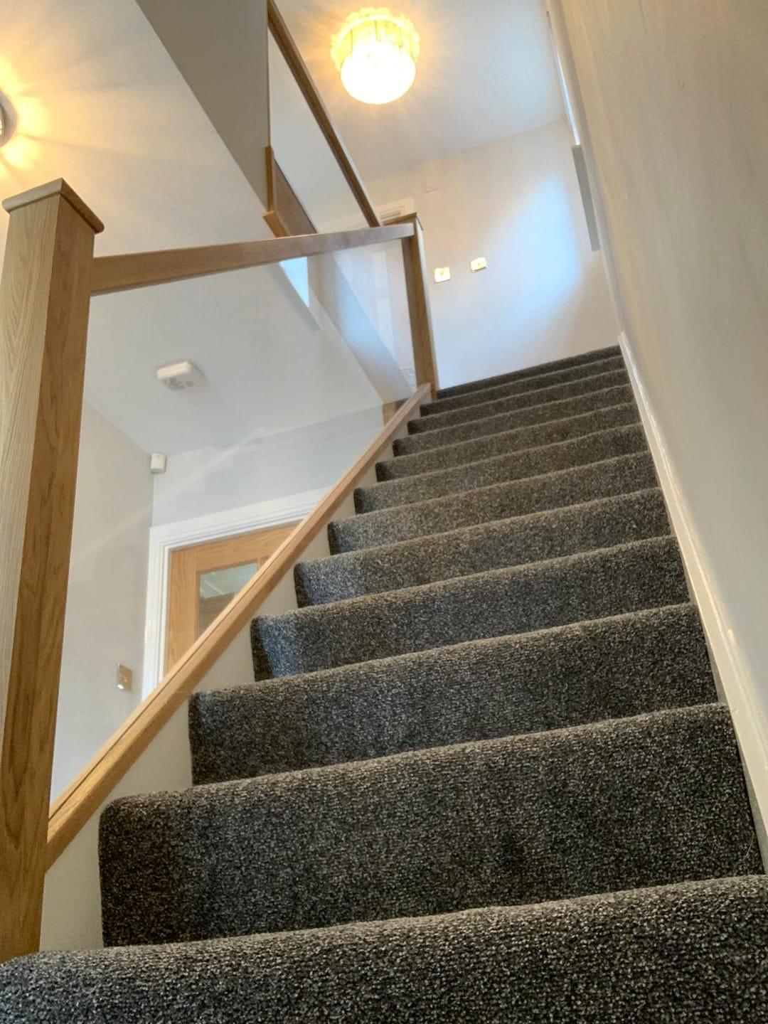 Oak and glass staircase with clear balustrade.